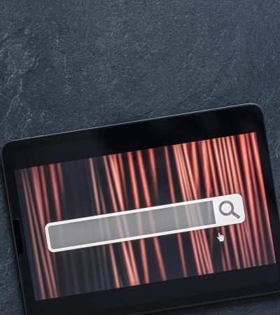 Digital tablet with internet browser search bar on screen, search searching browsing internet data information concept.